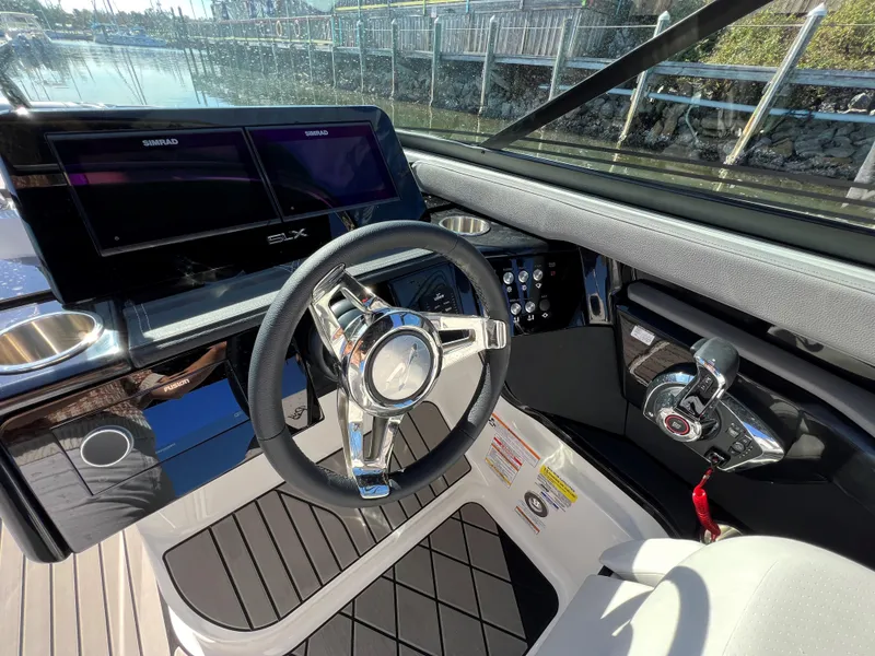 Slide: The Image of 2023 Sea Ray SLX 260 Outboard helm with modern controls and dual Simrad displays. - 14