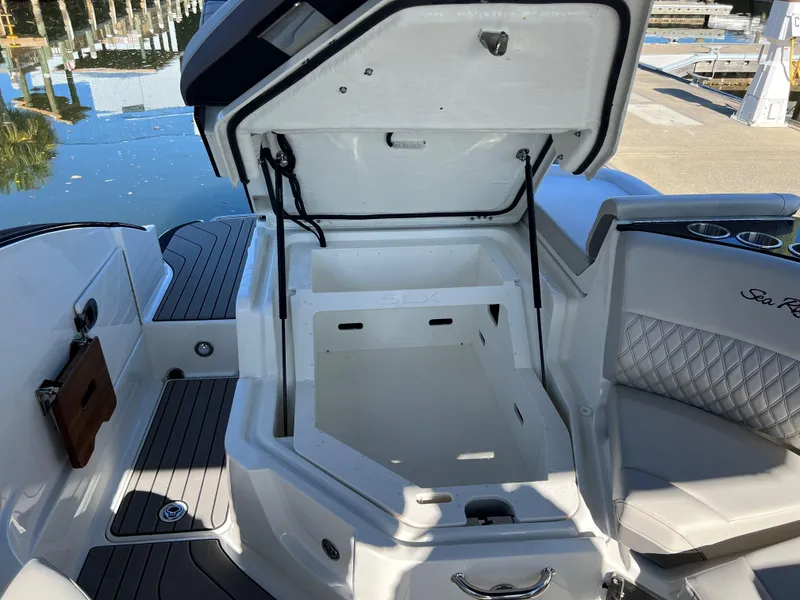 Slide: The Image of Open storage compartment on 2023 Sea Ray SLX 260 Outboard boat, dockside view. - 6