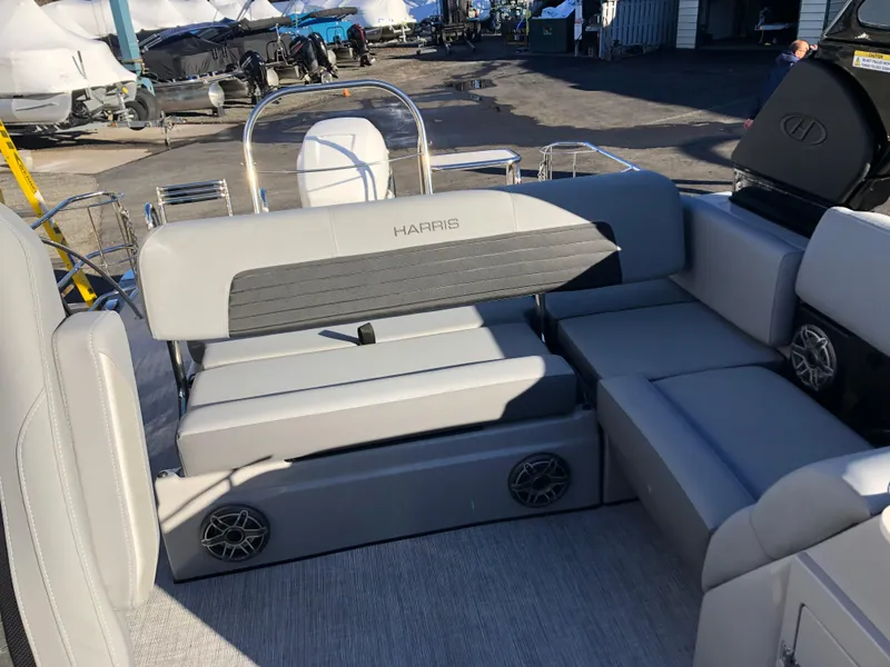 Slide: The Image of 2023 Harris Solstice 250 boat interior with gray seating and speakers. - 27
