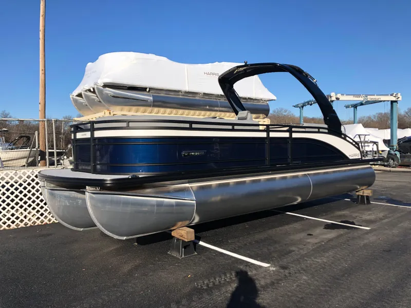Slide: The Image of 2023 Harris Solstice 250 pontoon boat on display in a marina. - 0