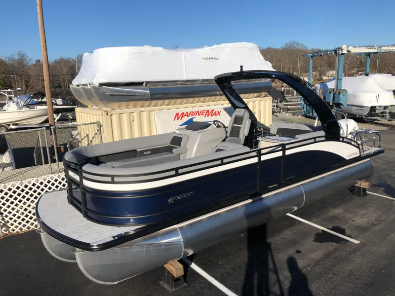 Slide: The Image of 2023 Harris Solstice 250 pontoon boat displayed at a marina. - 6