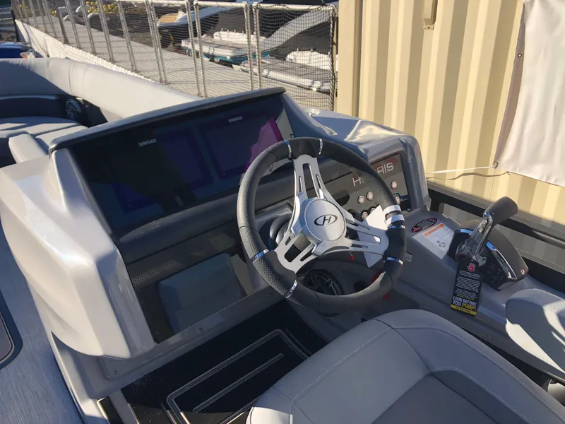 Slide: The Image of 2023 Harris Solstice 250 boat dashboard with steering wheel and controls. - 9