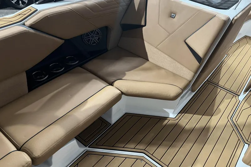 Slide: The Image of 2023 Nautique Super Air Nautique S25 interior with tan seating and teak flooring. - 17