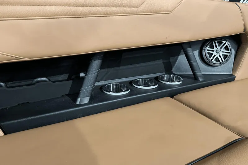 Slide: The Image of 2023 Nautique Super Air Nautique S25 interior with cup holders and speaker. - 19