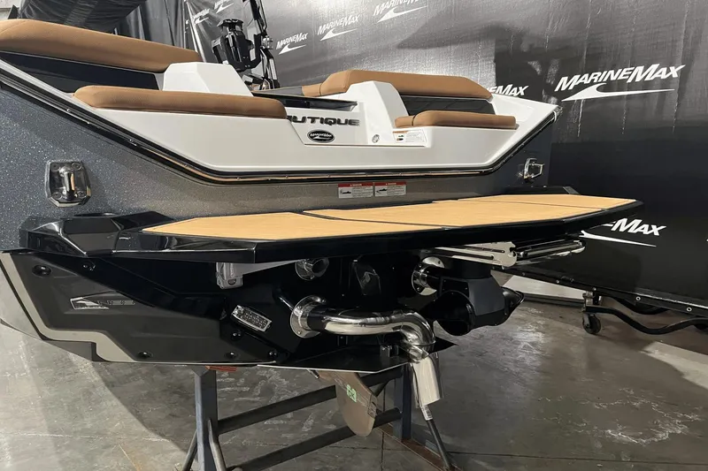 Slide: The Image of 2023 Nautique Super Air Nautique S25 boat rear view with teak swim platform. - 4