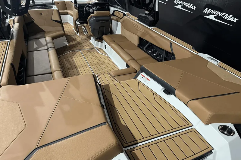 Slide: The Image of 2023 Nautique Super Air Nautique S25 interior with tan upholstery and spacious seating. - 6