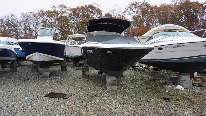 Slide: The Image of 2020 Sea Ray SPX 190 boat stored on blocks, surrounded by other boats, autumn trees in background. - 1