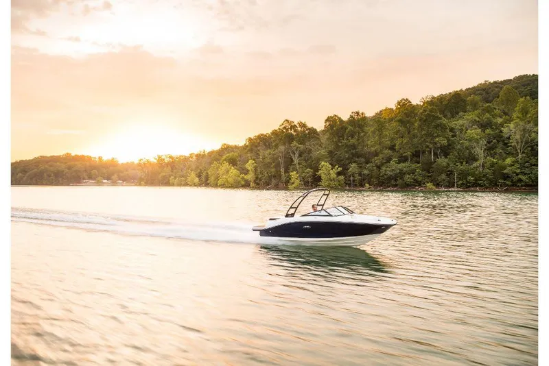 Slide: The Image of 2020 Sea Ray SPX 190 boat cruising on a serene lake at sunset. - 8