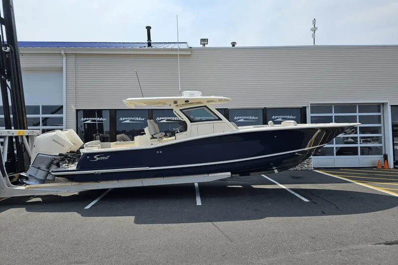 Slide: The Image of 2024 Scout 305 LXF boat displayed outside MarineMax dealership. - 0