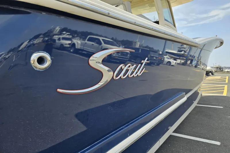 Slide: The Image of 2024 Scout 305 LXF boat with sleek blue exterior and logo. - 1