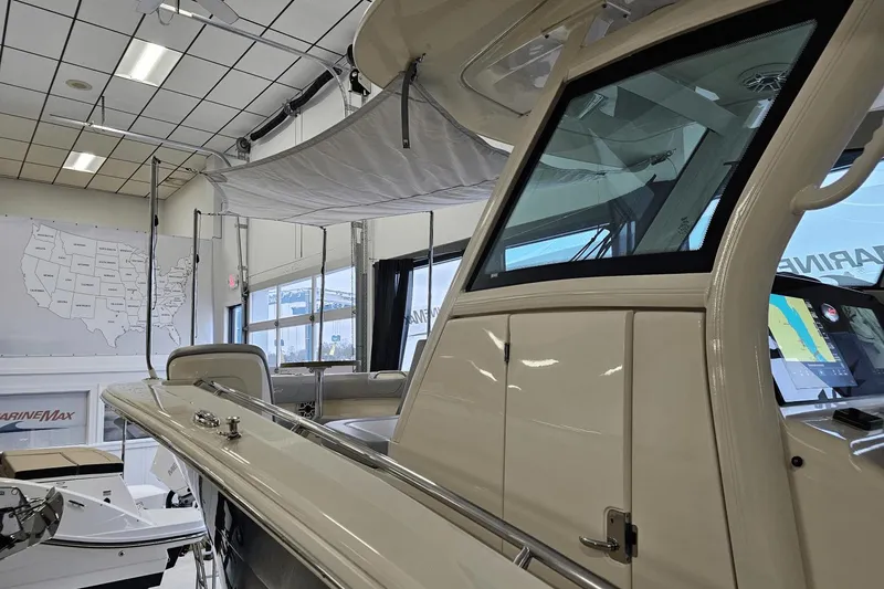 Slide: The Image of 2024 Scout 305 LXF boat interior in showroom with map and display. - 10