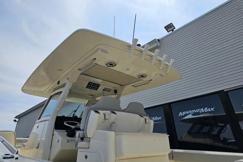 Slide: The Image of 2024 Scout 305 LXF boat at MarineMax dealership, showcasing helm and seating area. - 12
