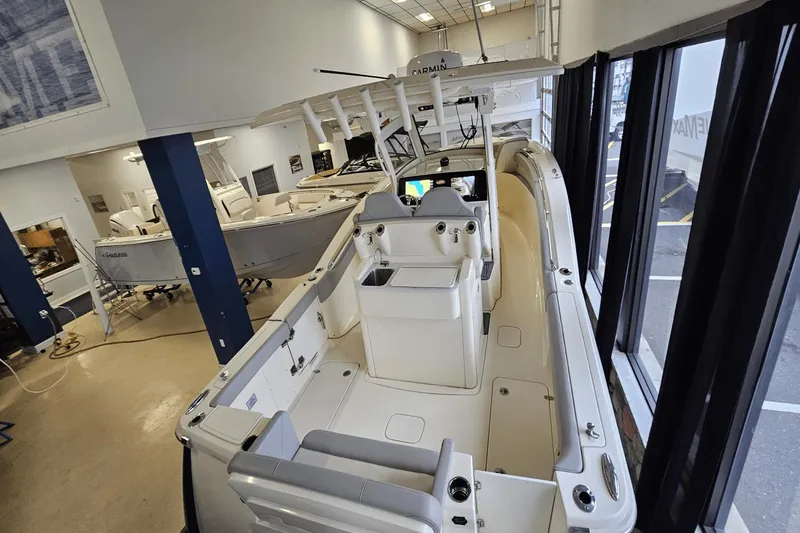 Slide: The Image of 2024 Scout 305 LXF boat displayed in a showroom, showcasing sleek design and modern features. - 13