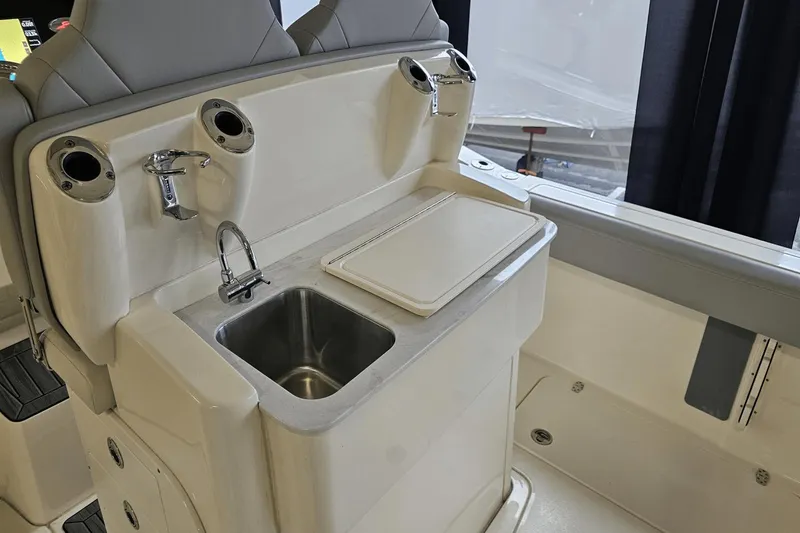 Slide: The Image of 2024 Scout 305 LXF boat interior with sink and cutting board station. - 19