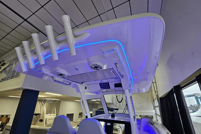 Slide: The Image of 2024 Scout 305 LXF boat interior with blue LED lighting and rod holders. - 21