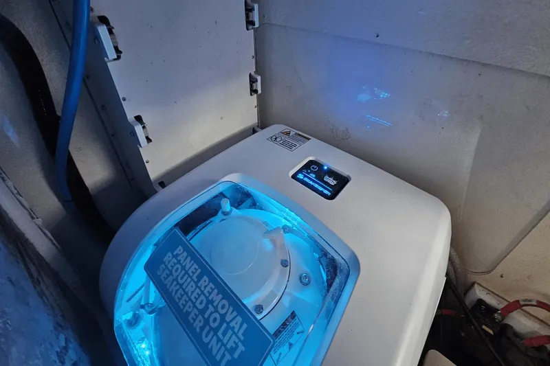 Slide: The Image of Seakeeper unit in 2024 Scout 305 LXF boat, illuminated with blue light. - 26