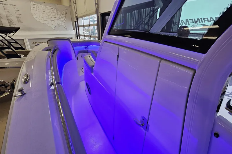 Slide: The Image of 2024 Scout 305 LXF boat interior with blue LED lighting in showroom. - 27