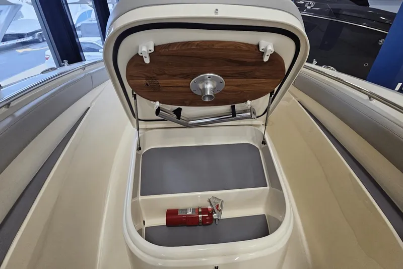 Slide: The Image of 2024 Scout 305 LXF boat storage compartment with fire extinguisher. - 35