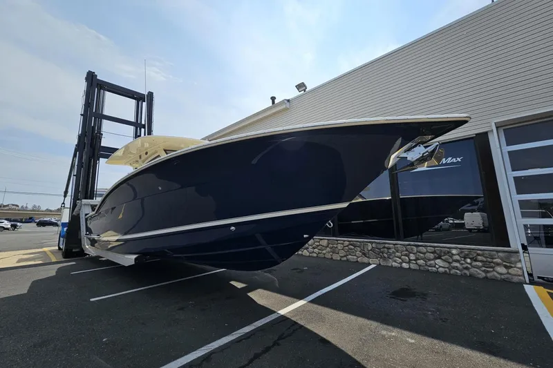 Slide: The Image of 2024 Scout 305 LXF boat on forklift outside a building, showcasing sleek design. - 4