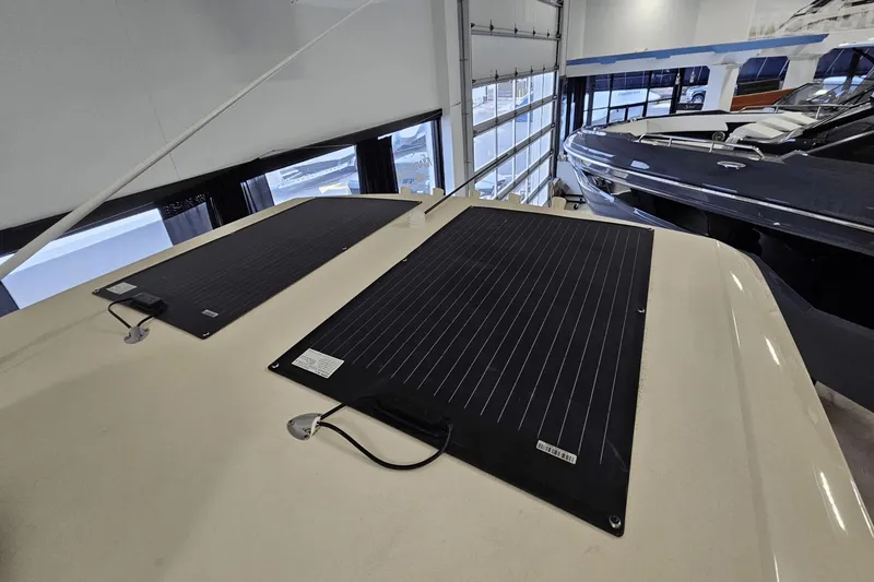Slide: The Image of 2024 Scout 305 LXF boat with solar panels on the roof in a showroom. - 43