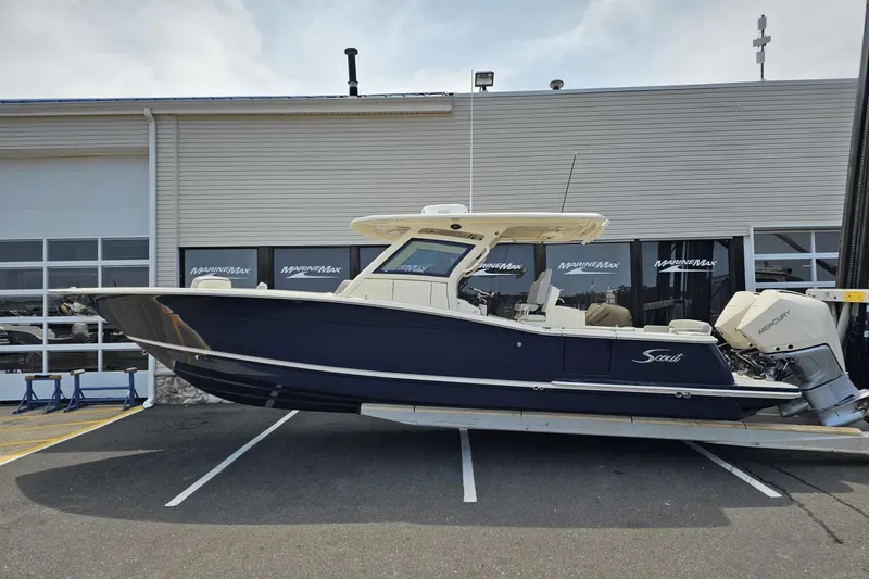 Slide: The Image of 2024 Scout 305 LXF boat displayed outside MarineMax dealership. - 7