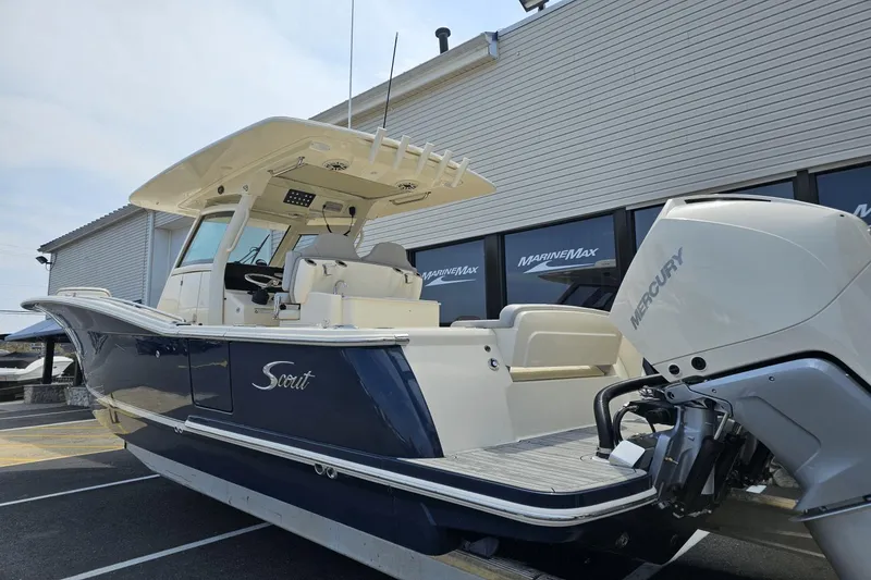 Slide: The Image of 2024 Scout 305 LXF boat with Mercury engine, displayed at MarineMax dealership. - 8