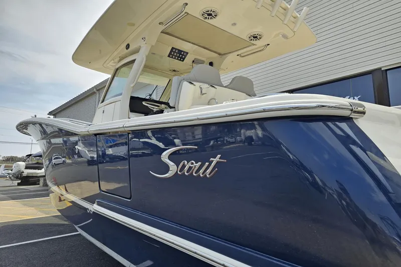 Slide: The Image of 2024 Scout 305 LXF boat with sleek blue hull and modern design. - 9