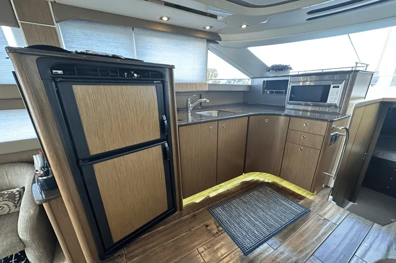 Slide: The Image of 2015 Meridian 441 Sedan yacht kitchen with modern appliances and wood cabinetry. - 48