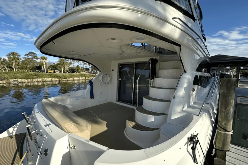 Slide: The Image of 2015 Meridian 441 Sedan yacht with elegant deck and spiral staircase, docked by serene waters. - 6