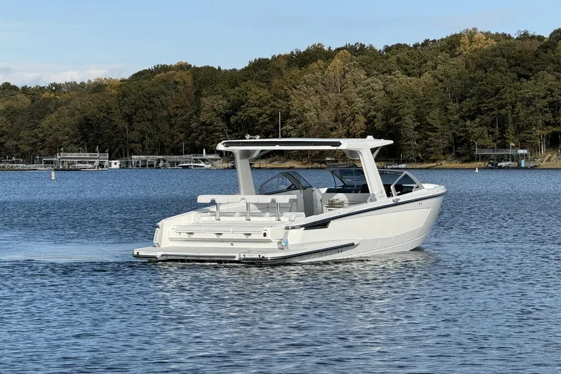 Slide: The Image of 2024 Aviara AV32 boat cruising on a serene lake with forested shoreline. - 3