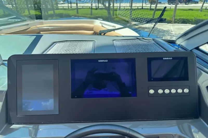 Slide: The Image of 2022 Aviara AV32 Outboard dashboard with Simrad displays and controls. - 11
