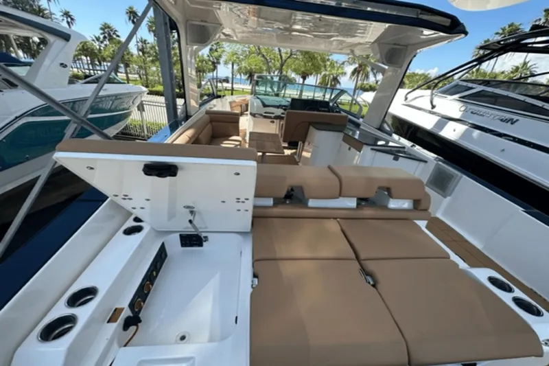 Slide: The Image of 2022 Aviara AV32 Outboard luxury boat interior with tan seating and open storage compartment. - 19