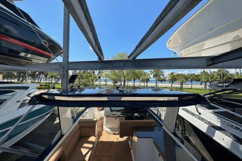 Slide: The Image of 2022 Aviara AV32 Outboard boat docked, surrounded by other boats, with a scenic waterfront view. - 20