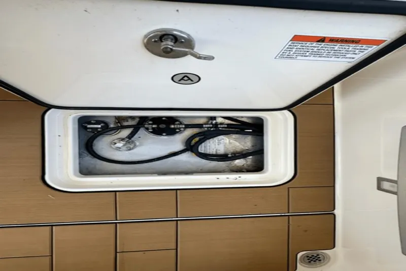 Slide: The Image of 2022 Aviara AV32 Outboard storage compartment with wiring and warning label. - 25