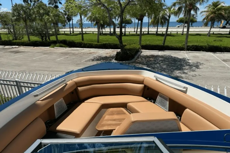 Slide: The Image of 2022 Aviara AV32 Outboard boat with tan seating, parked near a scenic waterfront. - 4