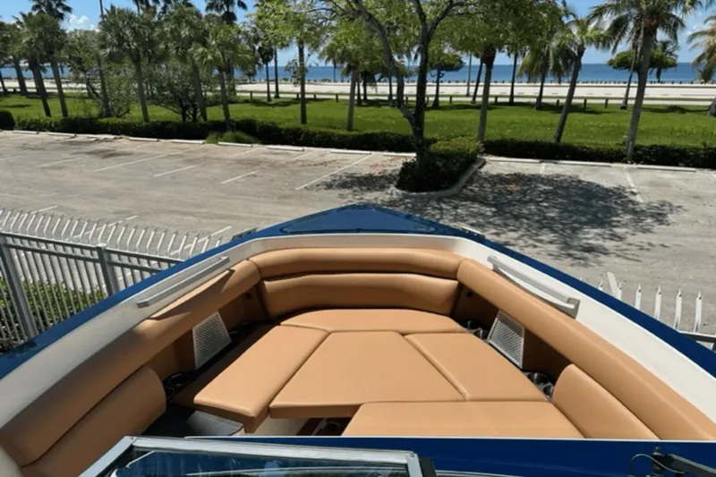 Slide: The Image of 2022 Aviara AV32 Outboard boat with tan seating, parked near a scenic waterfront. - 5