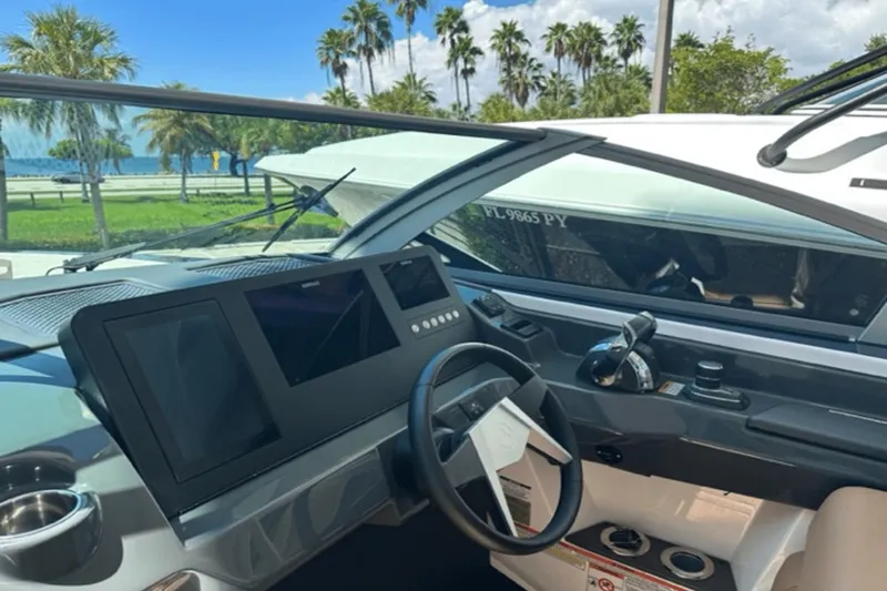 Slide: The Image of 2022 Aviara AV32 Outboard helm with modern controls and scenic waterfront view. - 6