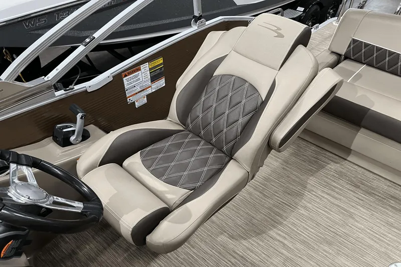 Slide: The Image of 2019 Bennington 23RSBDN boat interior with luxurious captain's chair and steering wheel. - 16