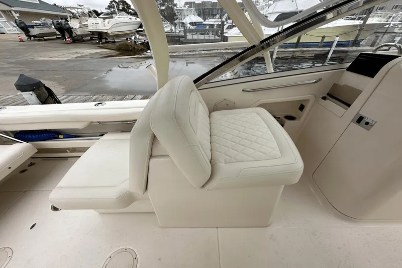 Slide: The Image of 2022 Grady-White 275 Freedom boat interior with cushioned seating at marina. - 16
