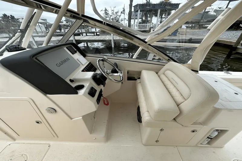 Slide: The Image of 2022 Grady-White 275 Freedom boat cockpit with Garmin navigation system and cushioned seating. - 19