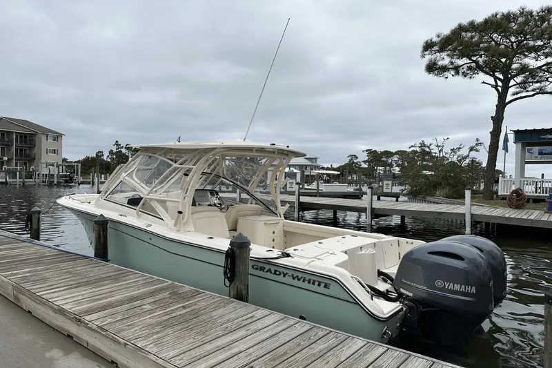 Slide: The Image of 2022 Grady-White 275 Freedom boat docked with Yamaha engine, overcast sky. - 2
