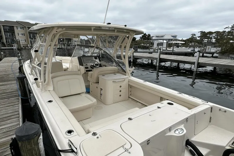 Slide: The Image of 2022 Grady-White 275 Freedom boat docked at marina, showcasing spacious seating and helm. - 9