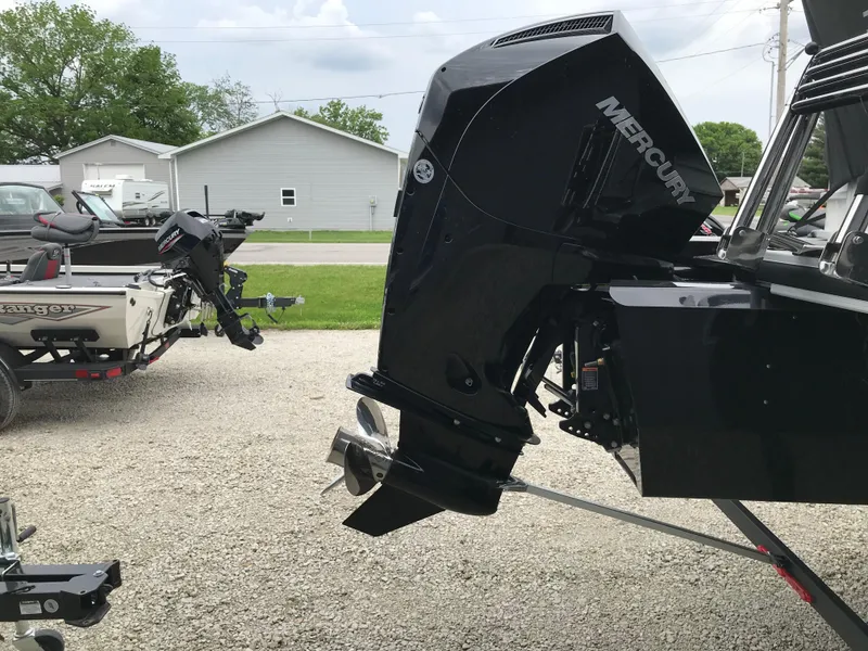 Slide: The Image of 2024 Ranger Reata 223C boat with Mercury outboard motor in a driveway. - 11