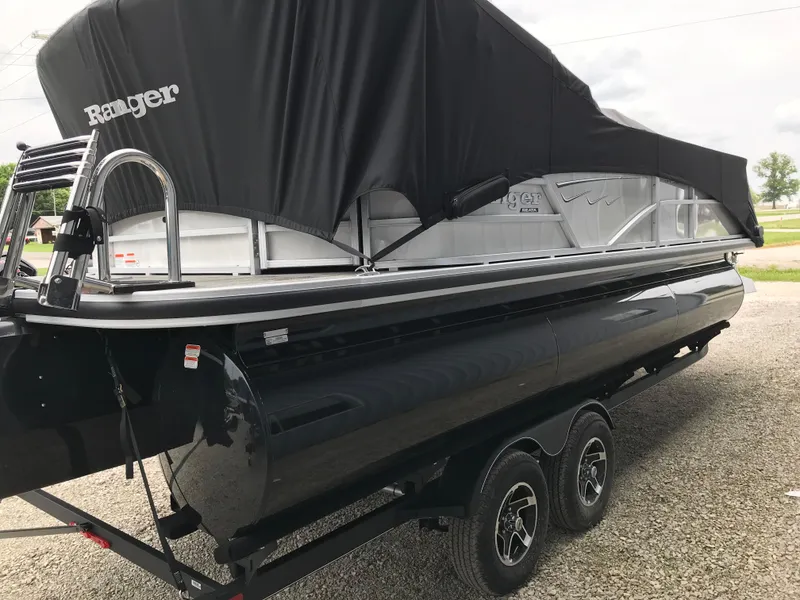 Slide: The Image of 2024 Ranger Reata 223C pontoon boat with black cover on trailer. - 12