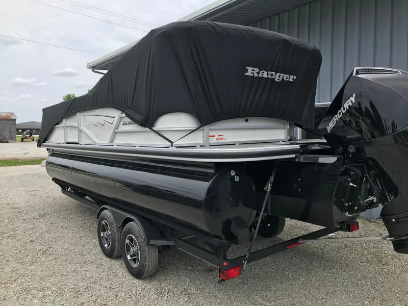 Slide: The Image of 2024 Ranger Reata 223C pontoon boat on a trailer with a black cover. - 13
