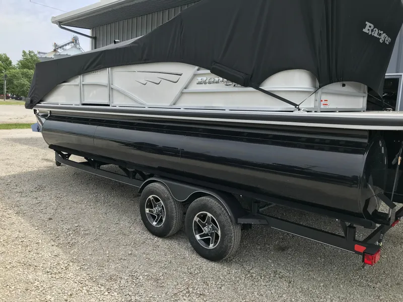 Slide: The Image of 2024 Ranger Reata 223C pontoon boat on a trailer, partially covered. - 19