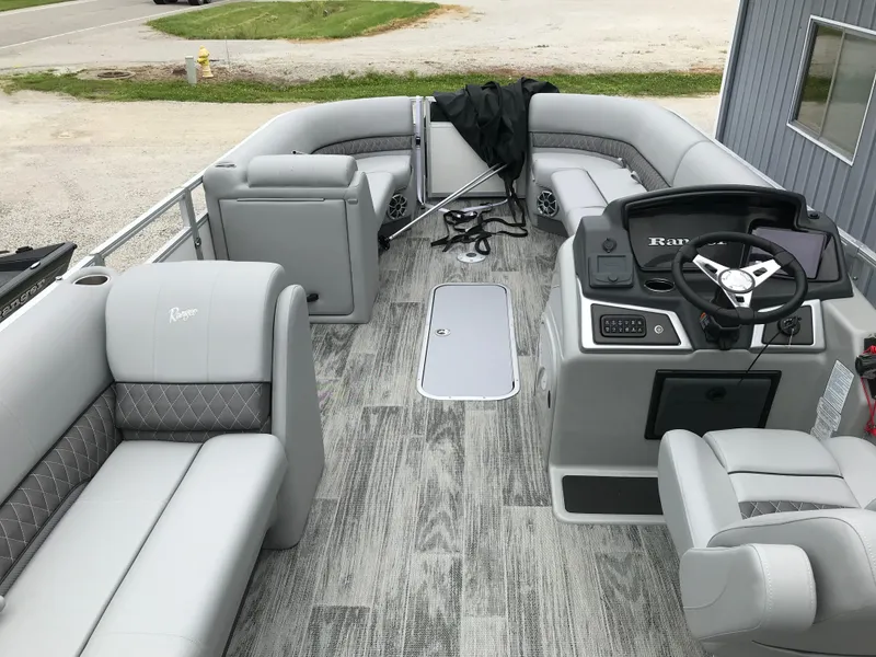 Slide: The Image of 2024 Ranger Reata 223C pontoon boat interior with gray seating and modern dashboard. - 4