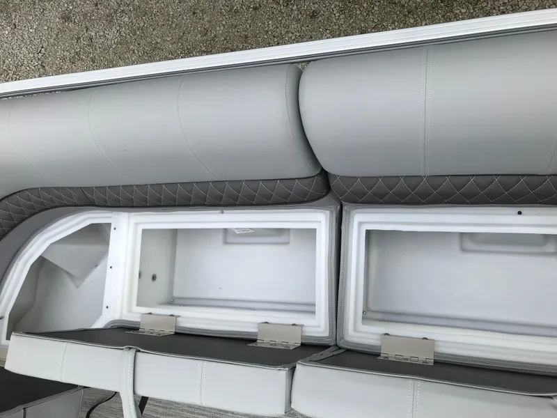 Slide: The Image of 2024 Ranger Reata 223C boat storage compartments with cushioned seating. - 8