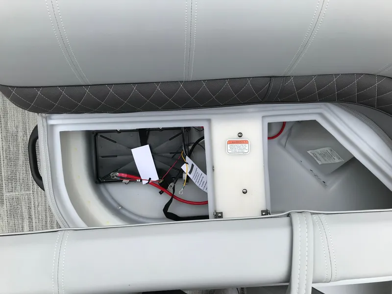 Slide: The Image of 2024 Ranger Reata 223C boat battery compartment with wiring and storage. - 9