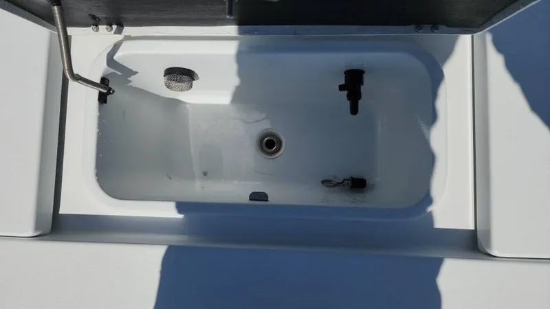 Slide: The Image of Livewell compartment on a 2020 Costa Custom Boats 264 HC, featuring plumbing and drainage. - 49